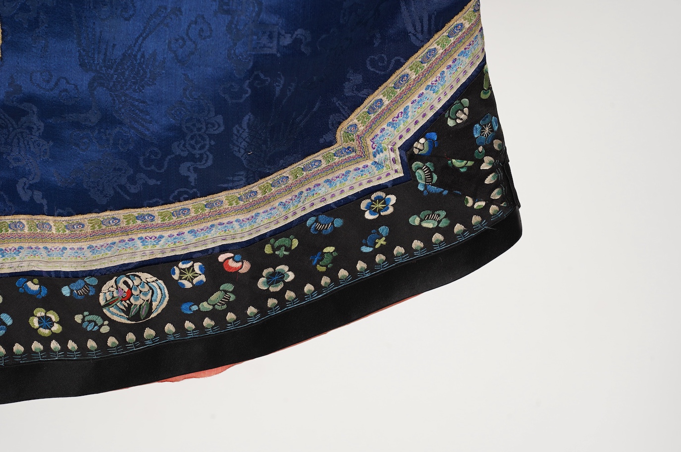 A late 19th century Chinese blue silk damask jacket, woven with Phoenix and auspicious symbols. The jacket edged with ornate rows of braiding and silk embroidery, the interior with original pink silk lining. The jacket f